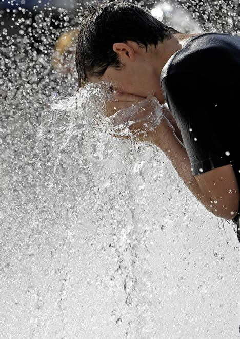 Un joven se refresca en una fuente de Pamplona en el que ha sido el quinto día intenso de calor que irá remitiendo a partir de esta tarde