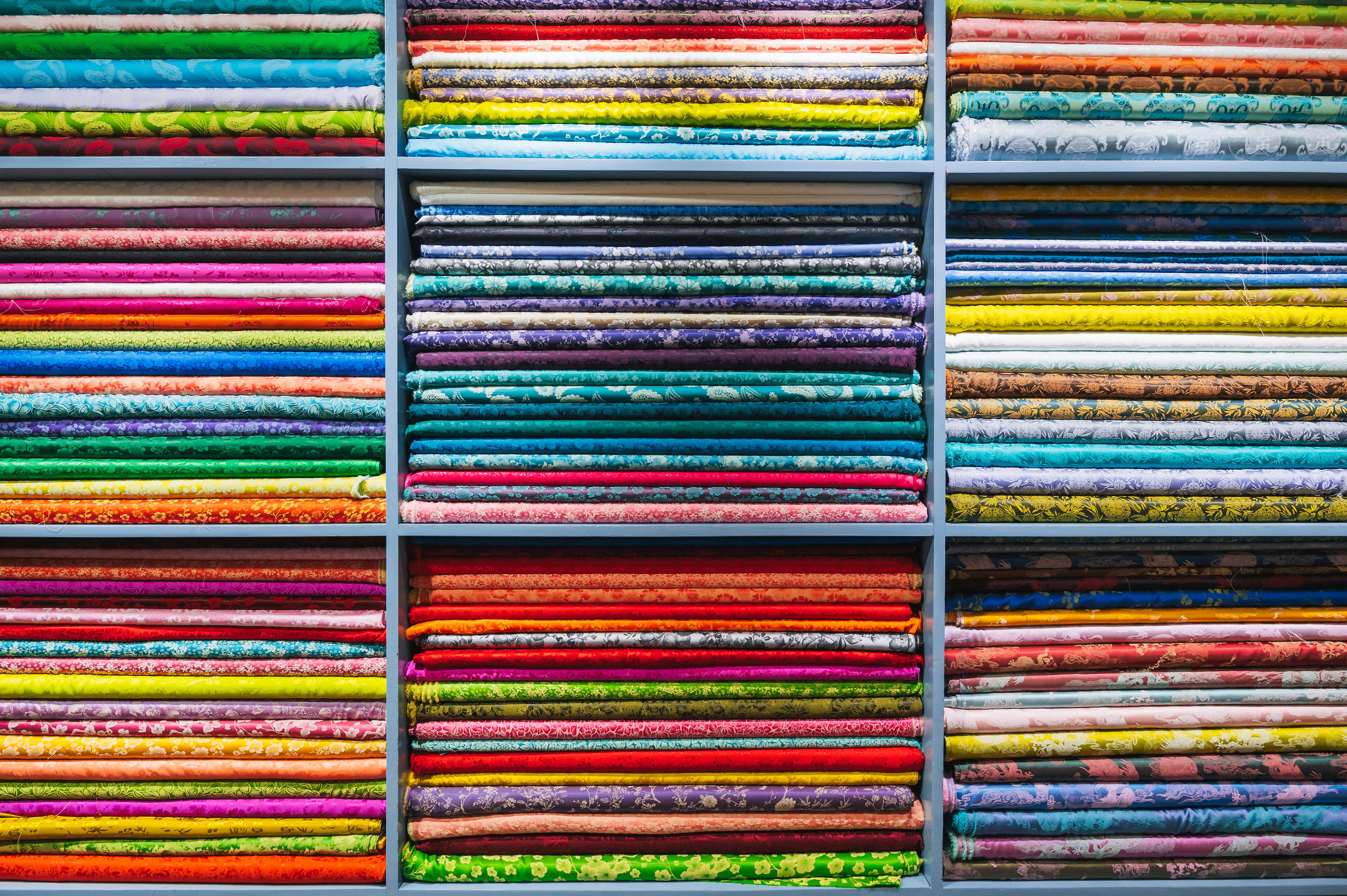 A close-up view of a folded bright and colorful fabric colors in the display of a retail store or atelier in Hoi an