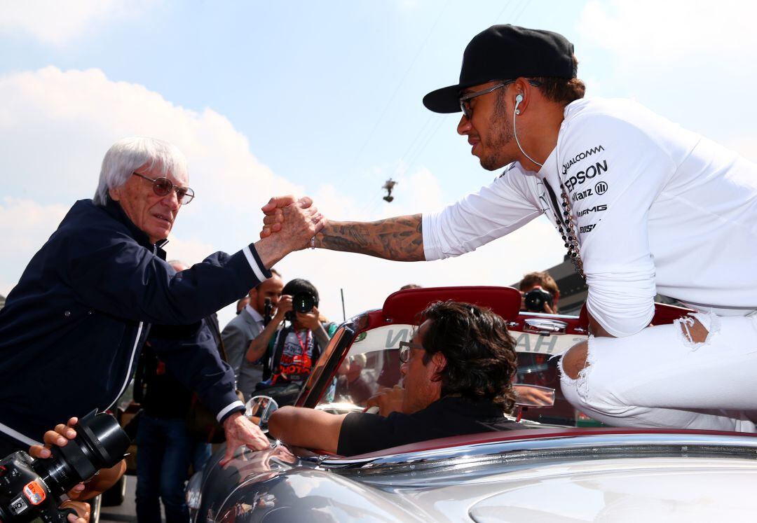 Bernie Ecclestone se da la mano con Lewis Hamilton