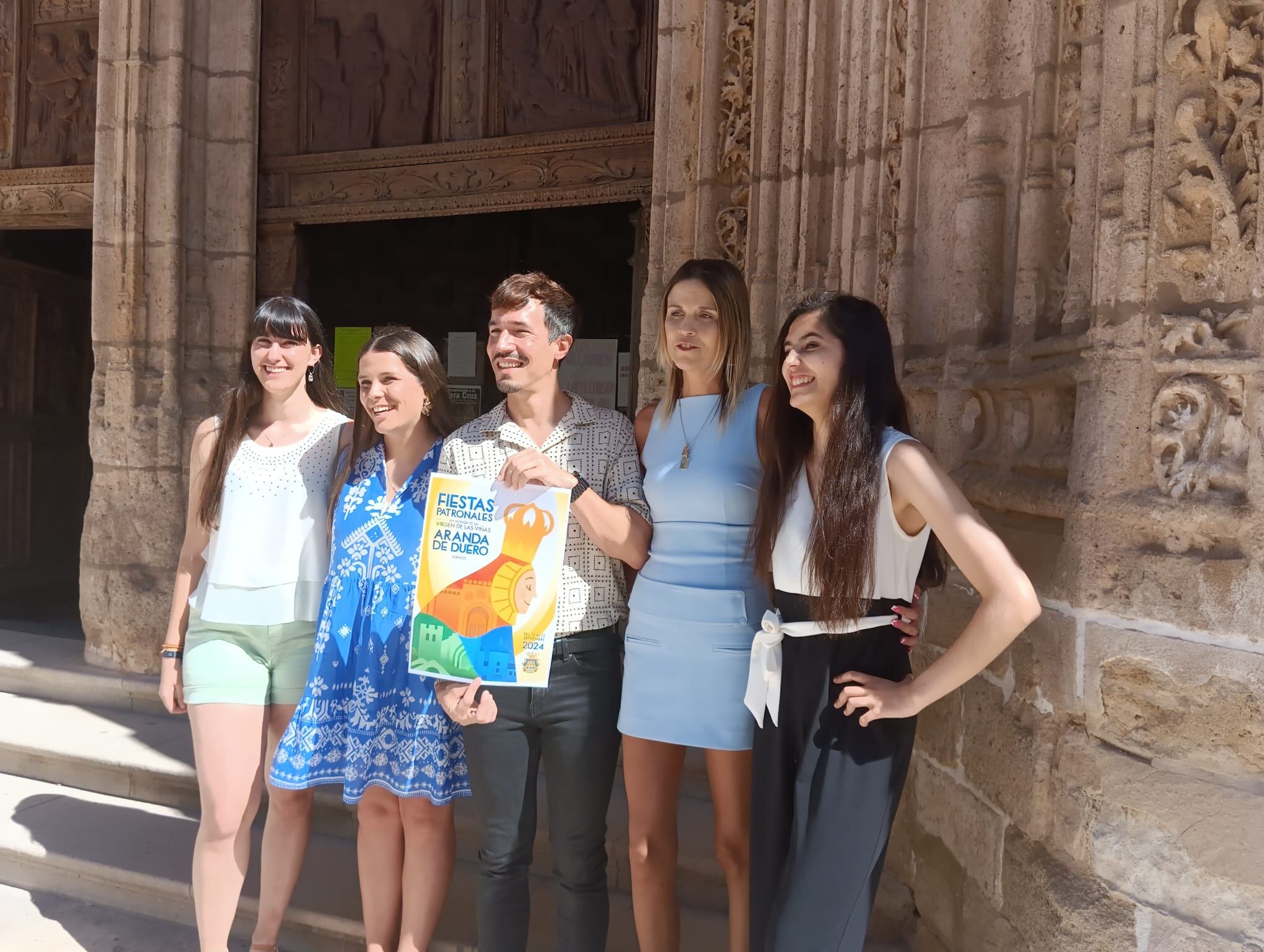 Las reinas y damas posan junto al autor del cartel en el pórtico de Santa María