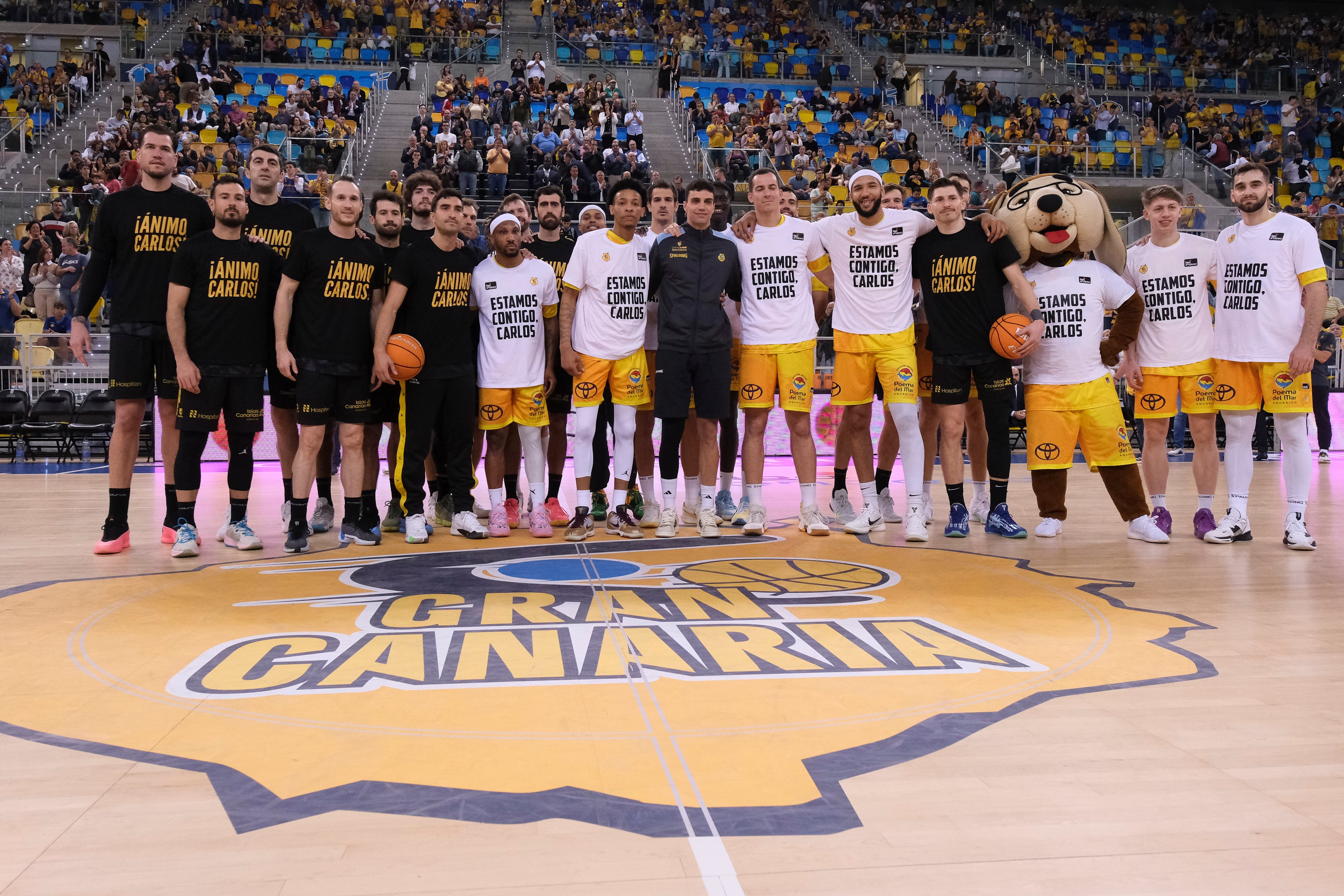 LAS PALMAS DE GRAN CANARIA, 26/01/2025.- Los jugadores del Dreamland Gran Canaria y de La Laguna Tenerife, homenajearon al jugador amarillo Carlos Alocén, que se perderá lo que queda de temporada por una lesion. Este apoyo se produjo antes del partido perteneciente a la décimo octava jornada de la Liga Endesa, que ambos equipos han jugado este domingo en el Gran Canaria Arena. EFE/Ángel Medina G.
