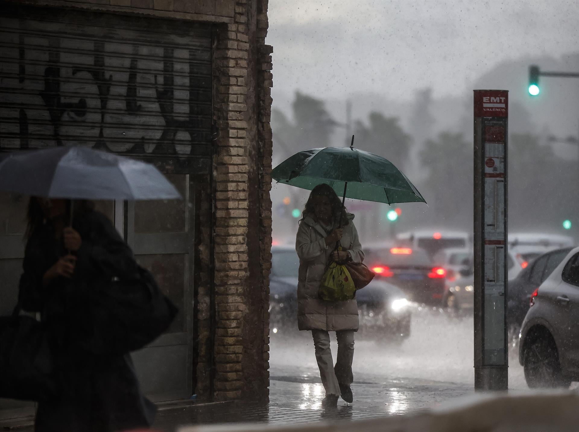 Dos mujeres caminan mientras se protegen de la lluvia con paraguas, a 11 de noviembre de 2022, en València.