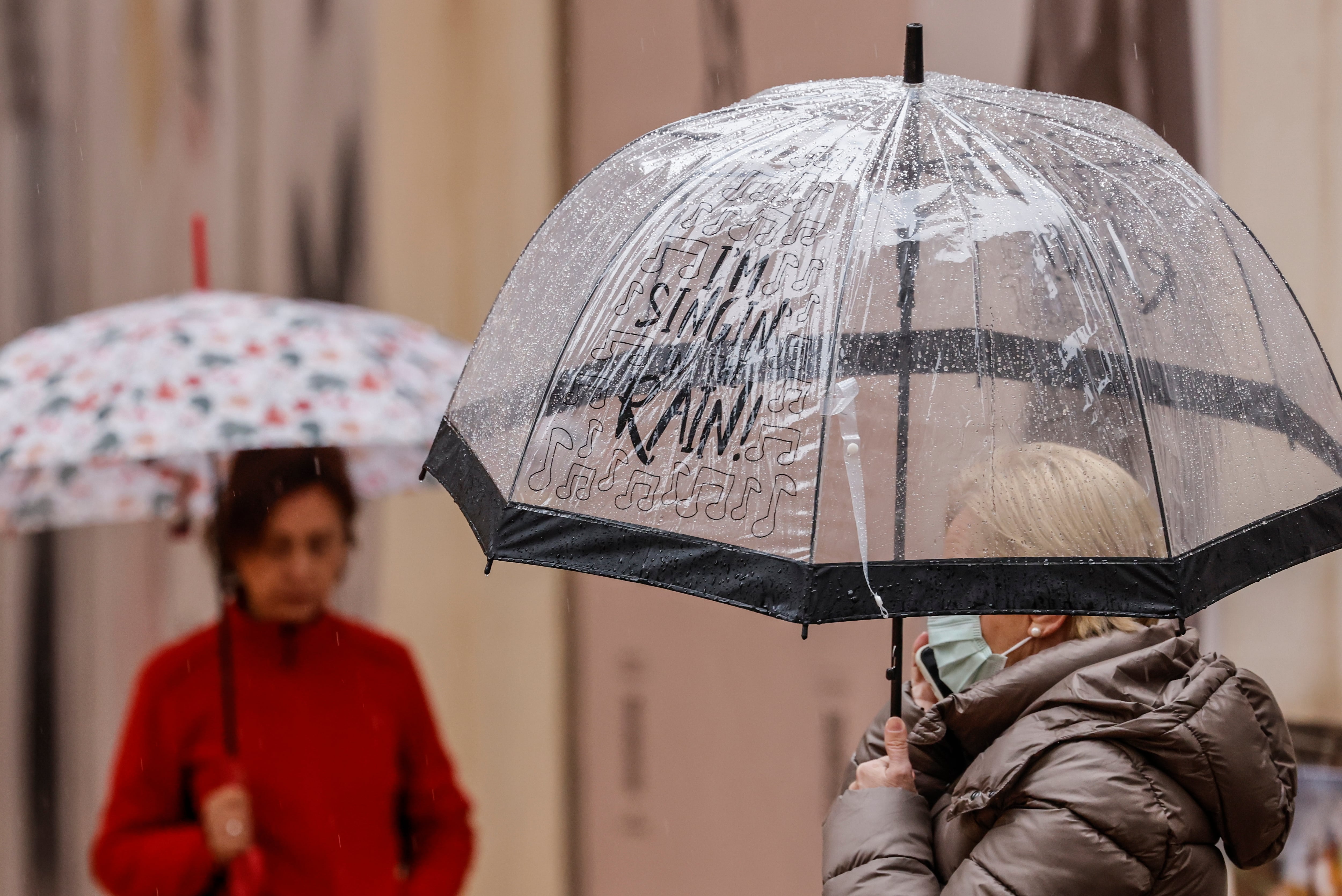 VALENCIA, 19/01/2024.- Varias personas se protegen con paraguas de la lluvia que ha empezado a caer en la ciudad de València este viernes. La borrasca Juan mantiene en alerta al interior de la mitad norte y casi todo el litoral, con quince comunidades en alerta por nevadas, lluvia, viento u oleaje, de las cuales Aragón y Castilla y León están en naranja (riesgo importante) y por la tarde lo harán también Andalucía y la Comunidad Valenciana.EFE/Ana Escobar
