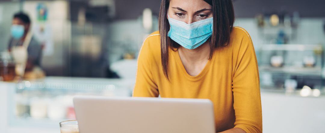 Empresaria consulta un ordenador en su negocio