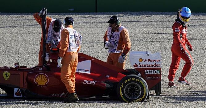 Fernando Alonso contempla su coche tras salirse de pista