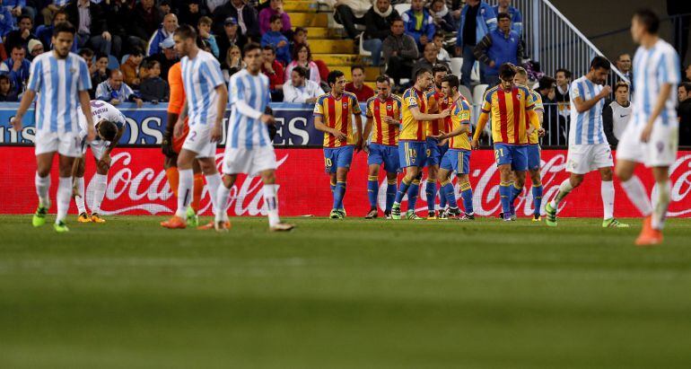 Los jugadores del Valencia CF celebran el gol del portero camerunés del Málaga CF Idriss Carlos Kameni, en propia puerta,