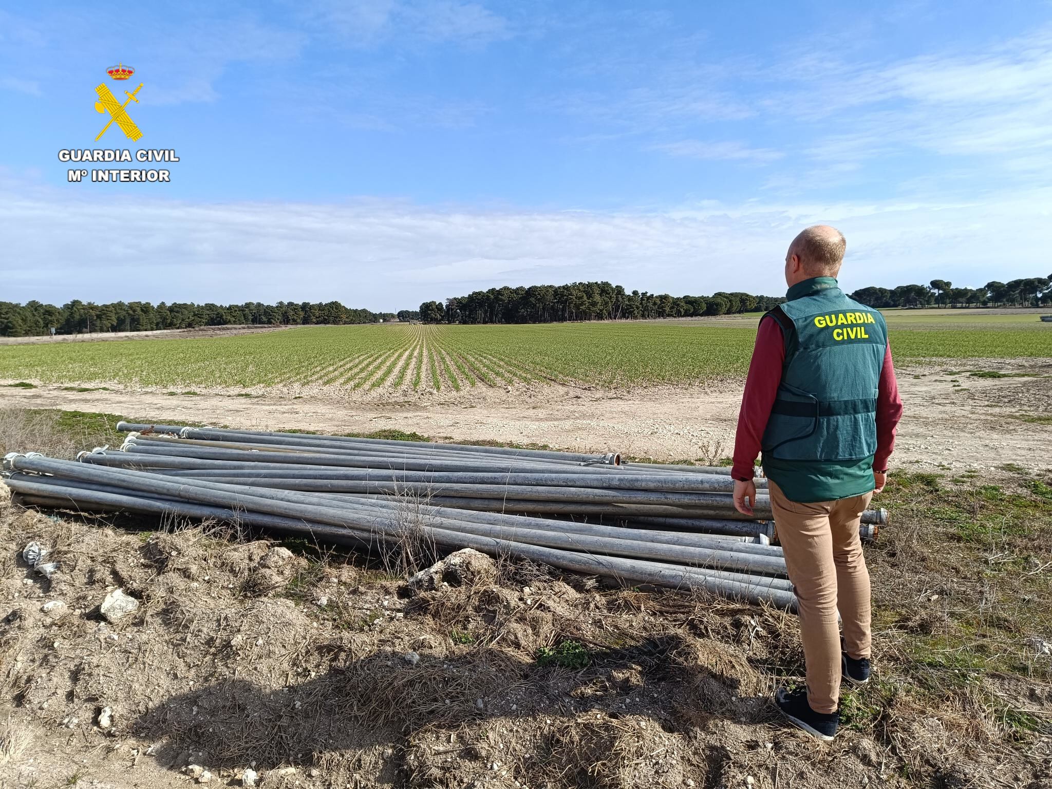 Un agente del equipo Roca de la Guardia Civil observa tubos de regadío