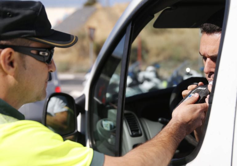 Un conductor realiza una prueba de alcoholemia.