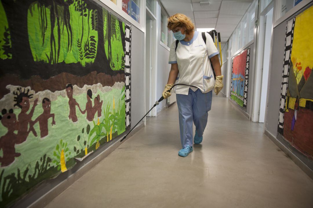 Personal de un colegio desinfectando el centro.