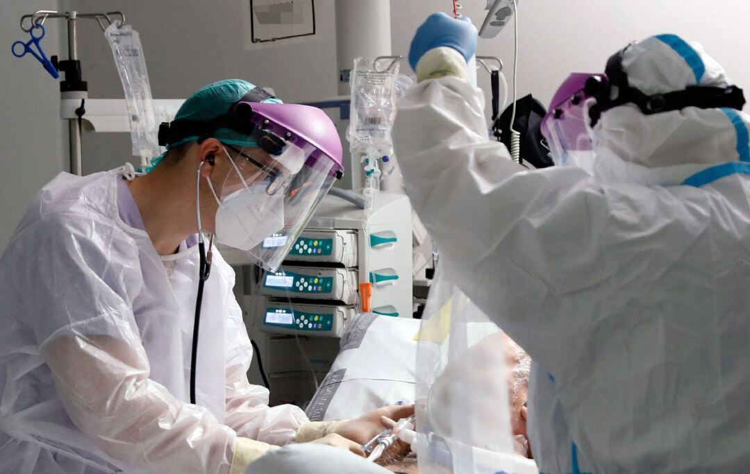 Personal sanitario atienden a un paciente en la Unidad de Cuidados Intensivos del Hospital La Fé de Valencia.