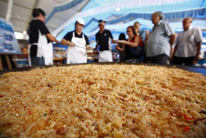 Dos trabajadores preparan en Valencia el salpicón de marisco más grande del mundo.