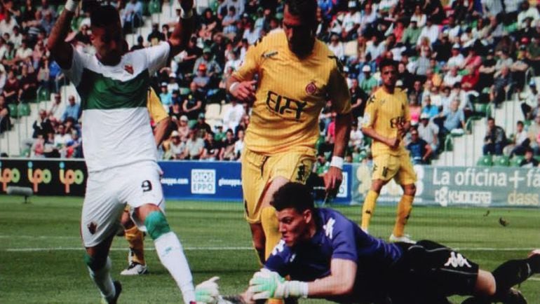 Becerra atrapa un balón ante el delantero del Elche C.F. Sergio León