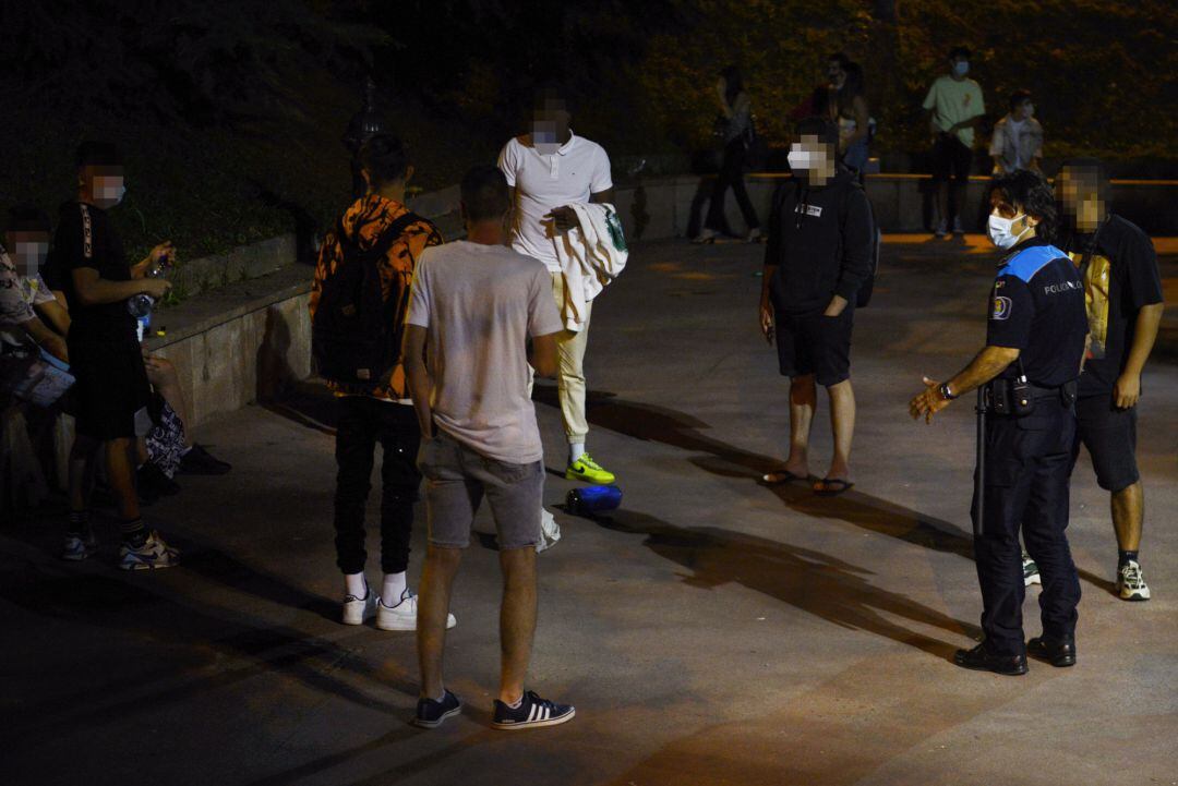 Un agente de la Policía Local informa a un grupo de jóvenes que disfruta de lanoche