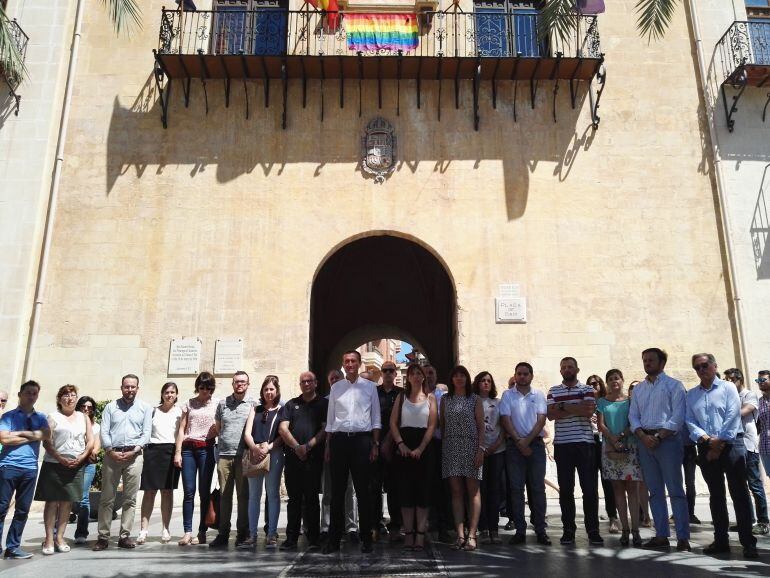 Concentación en la plaza de Baix con la bandera arcoiris en el Ayuntamiento