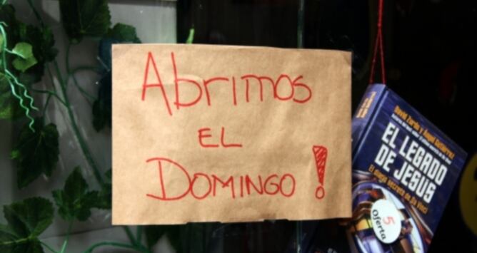 Cartell en un establiment del carrer Astúries de Barcelona on s'informa als potencials clients que els diumenges tindrà obert, en el primer dia amb el nou horari