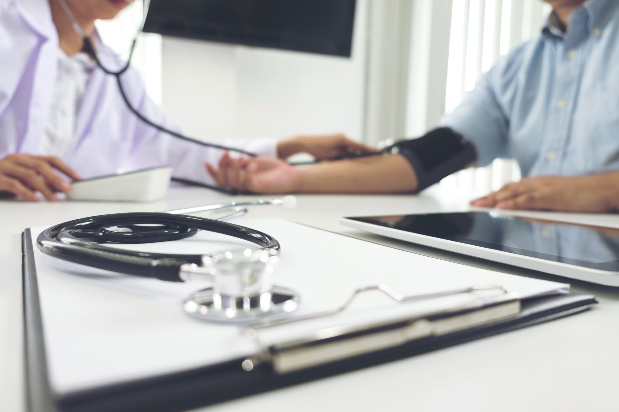 Un médico toma la presión a un paciente.