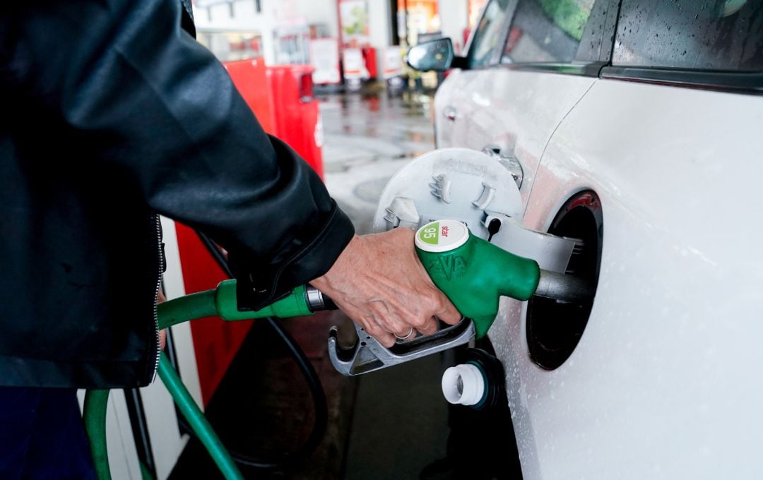 Una mujer pone gasolina a su vehículo en una gasolinera.