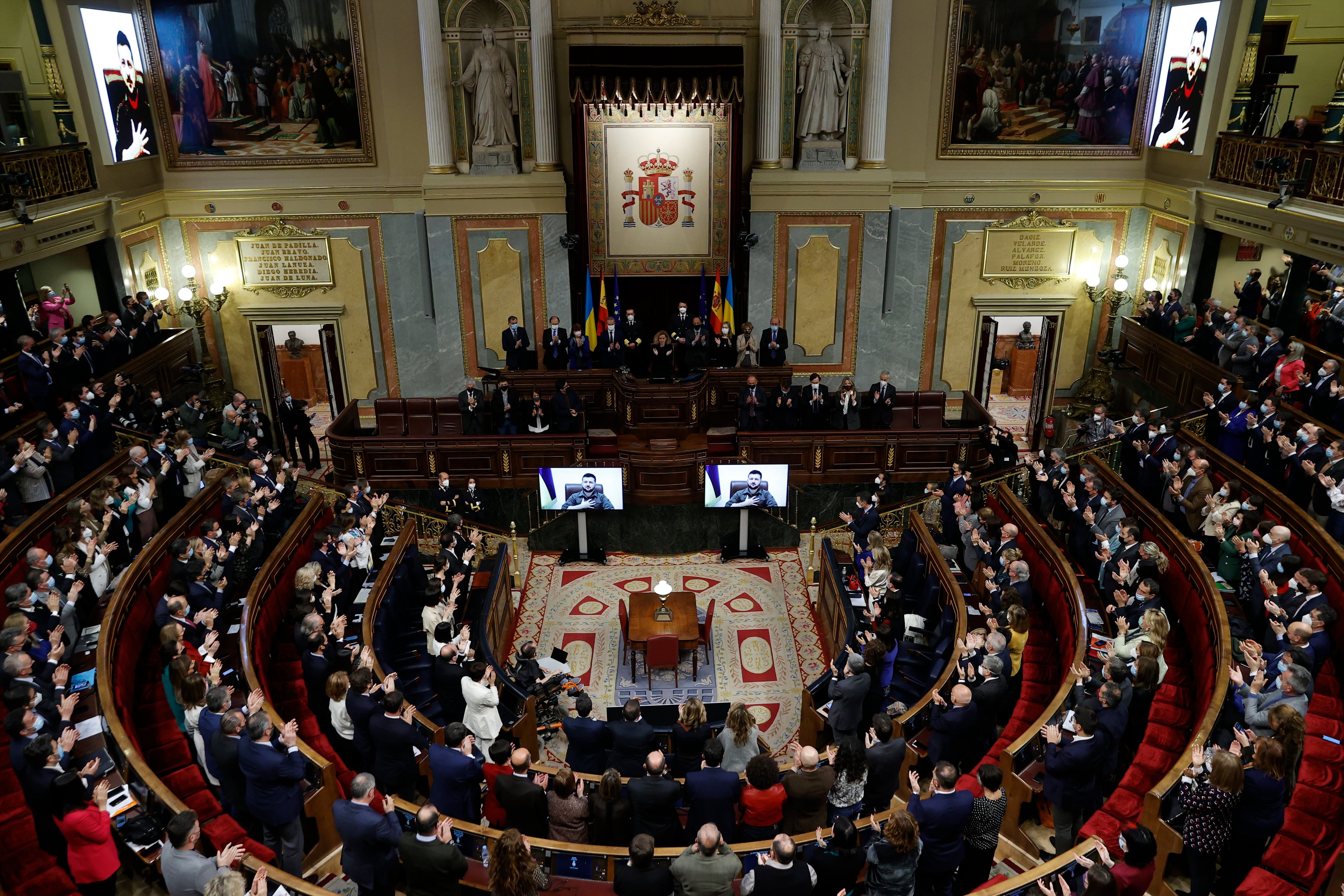 El pleno del Congreso de los Diputados, aplaude al presidente de Ucrania, Volodímir Zelensky, que ha comparecido por videoconferencia ante la cámara baja a petición unánime de todos los grupos parlamentarios