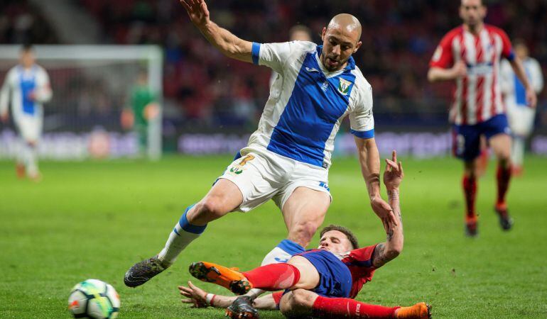 Nordin Amrabat (i) intenta llevarse el balón ante el centrocampista del Atlético de Madrid, Saúl Ñiguez, durante el encuentro correspondiente a la jornada 26 de primera división que disputó en el estadio Wanda Metropolitano de Madrid.