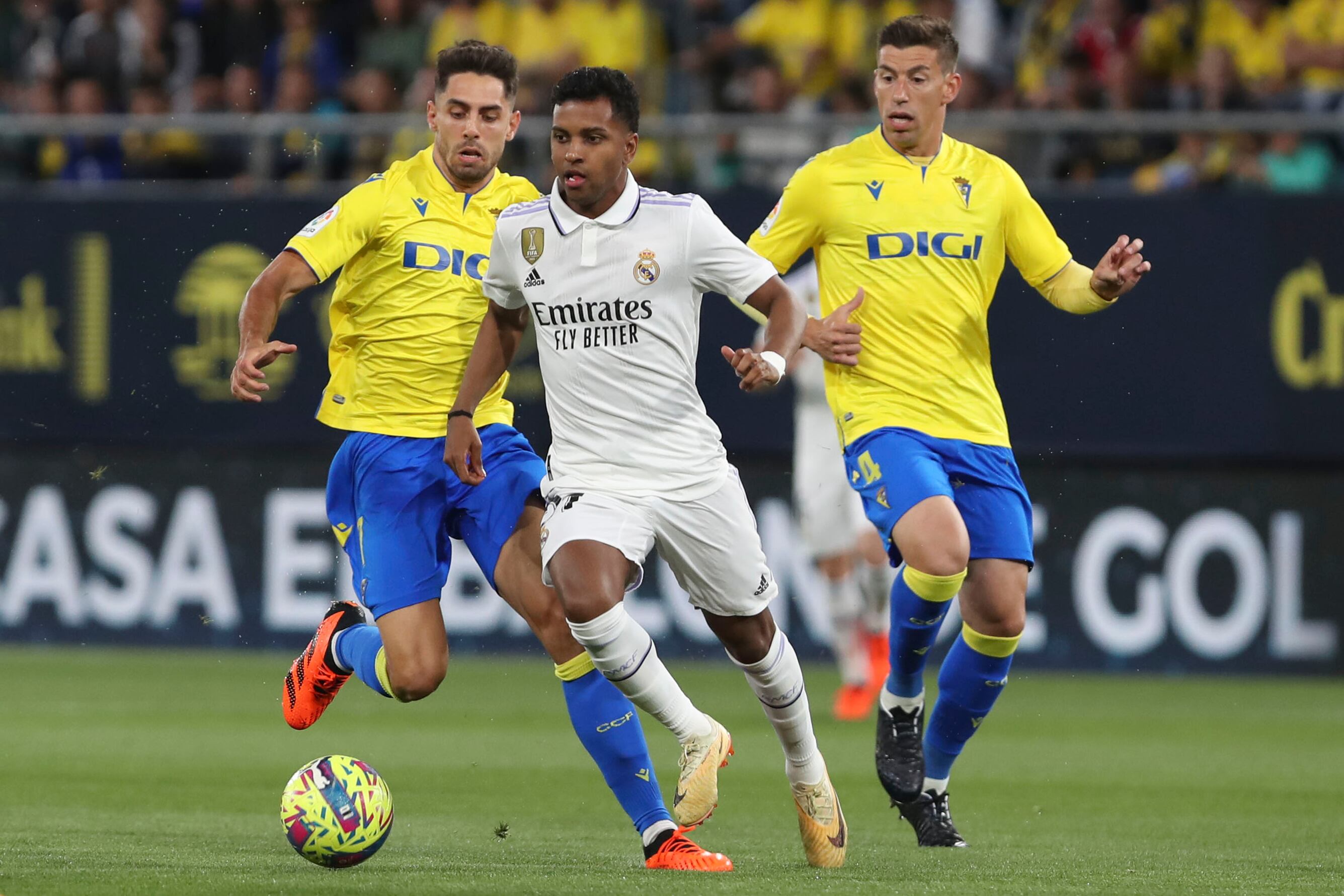 CÁDIZ, 15/04/2023.- El delantero brasileño del Real Madrid CF, Rodrygo Goes (c) lucha por el balón con el centrocampista del Cádiz CF, Rubén Alcaráz, durante el partido de LaLiga que enfrenta este sábado al Cádiz CF y al Real Madrid FC en el Estadio Nuevo Mirandilla (Cádiz). EFE/Román Ríos.
