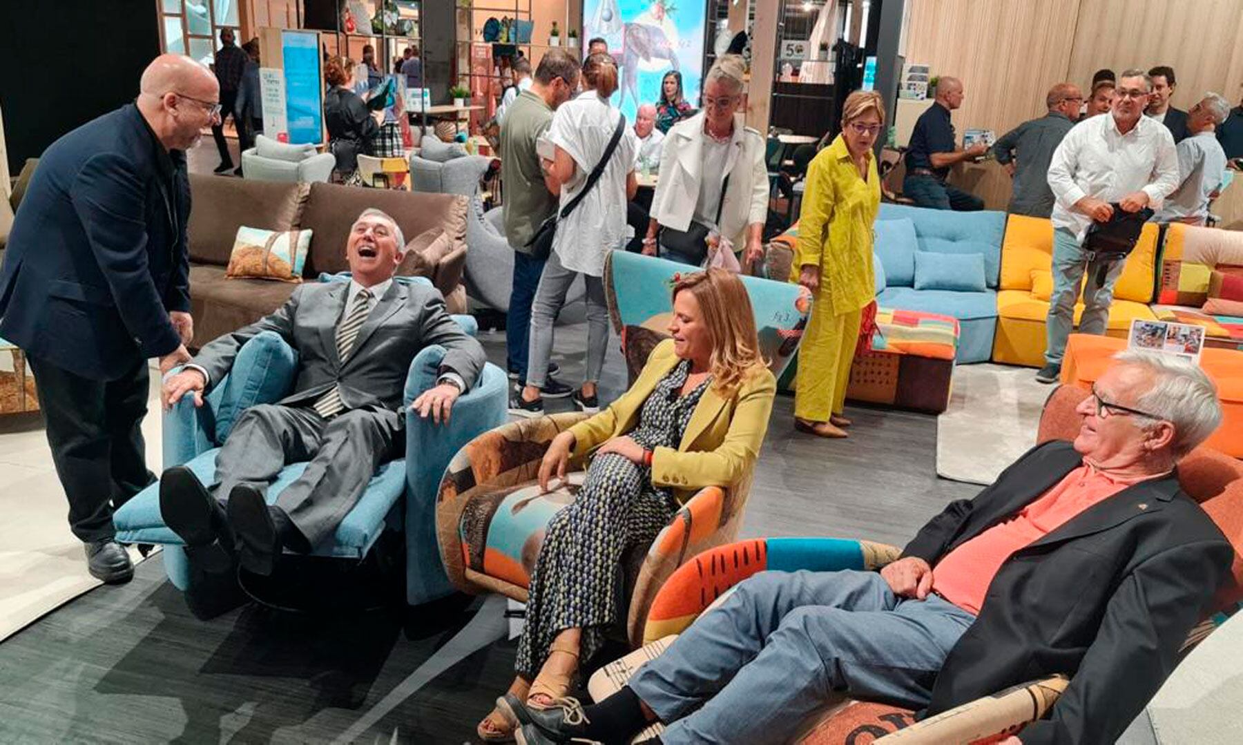 Divertida imagen del conseller Climent probando uno de los sillones expuestos junto al resto de autoridades