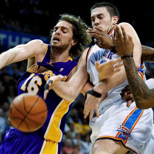 El jugador de los Lakers Pau Gasol se disputa el balón con el jugador de los Thunders Nick Collison, durante la primera mitad del partido disputado en Oklahoma