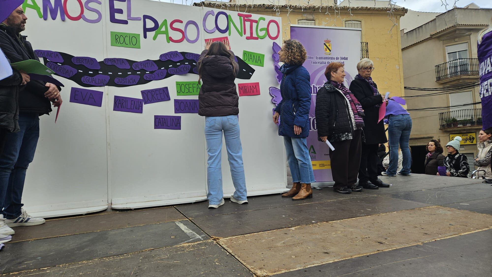 Una alumna de los colegios de Jódar coloca la pegatina con el nombre de una de las mujeres asesinadas