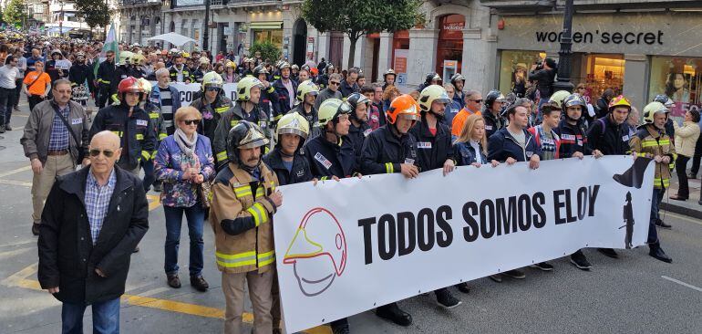 La manifestación de bomberos pasa ante el edificio incendiado, hace ahora dos años