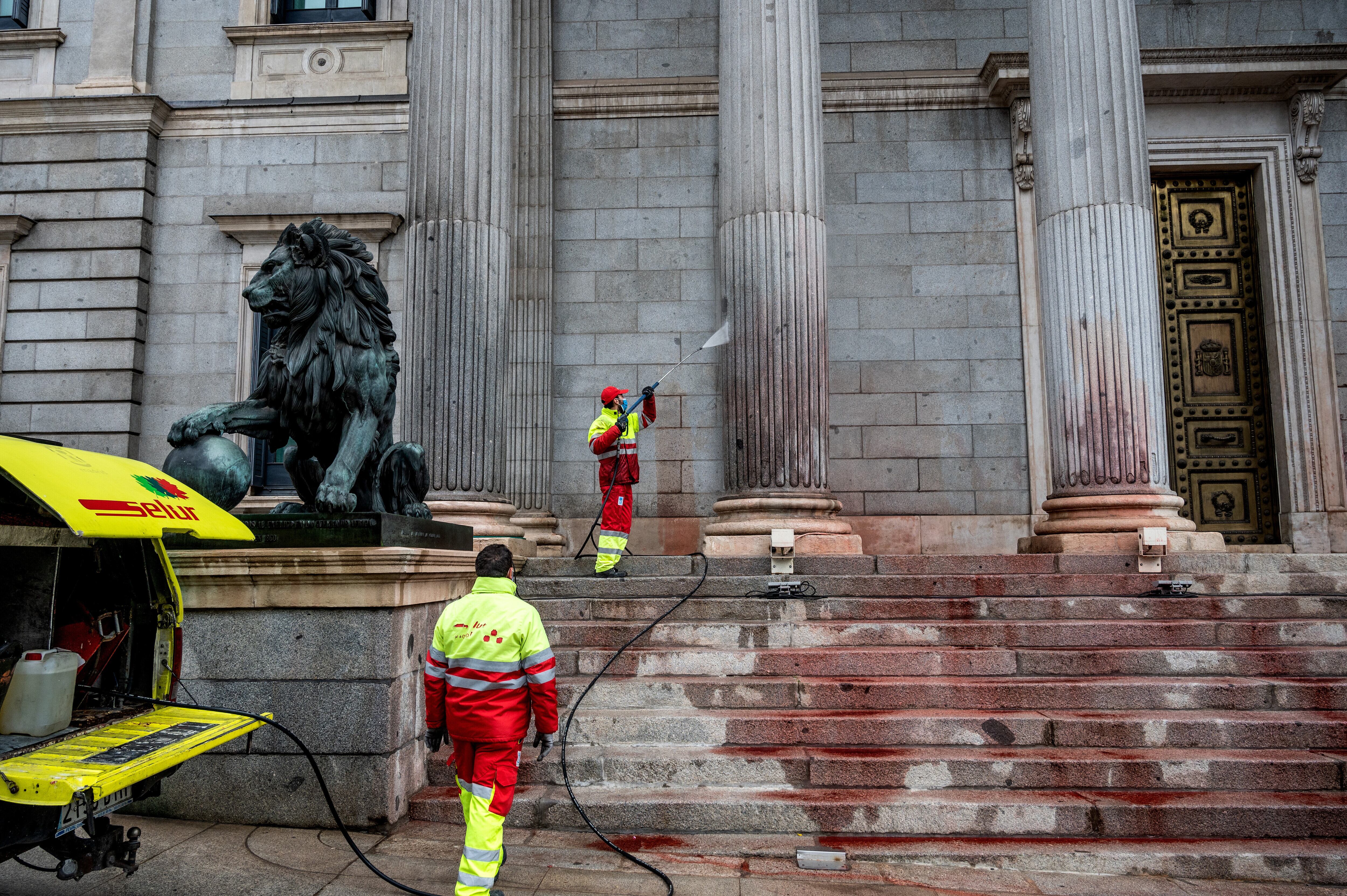 Trabajadores limpiando el Congreso tras el lanzamiento de pintura