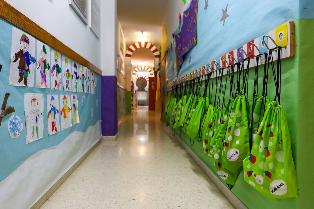 Pasillo con dibujos y mochilas colgadas en un centro de Educación Infantil.