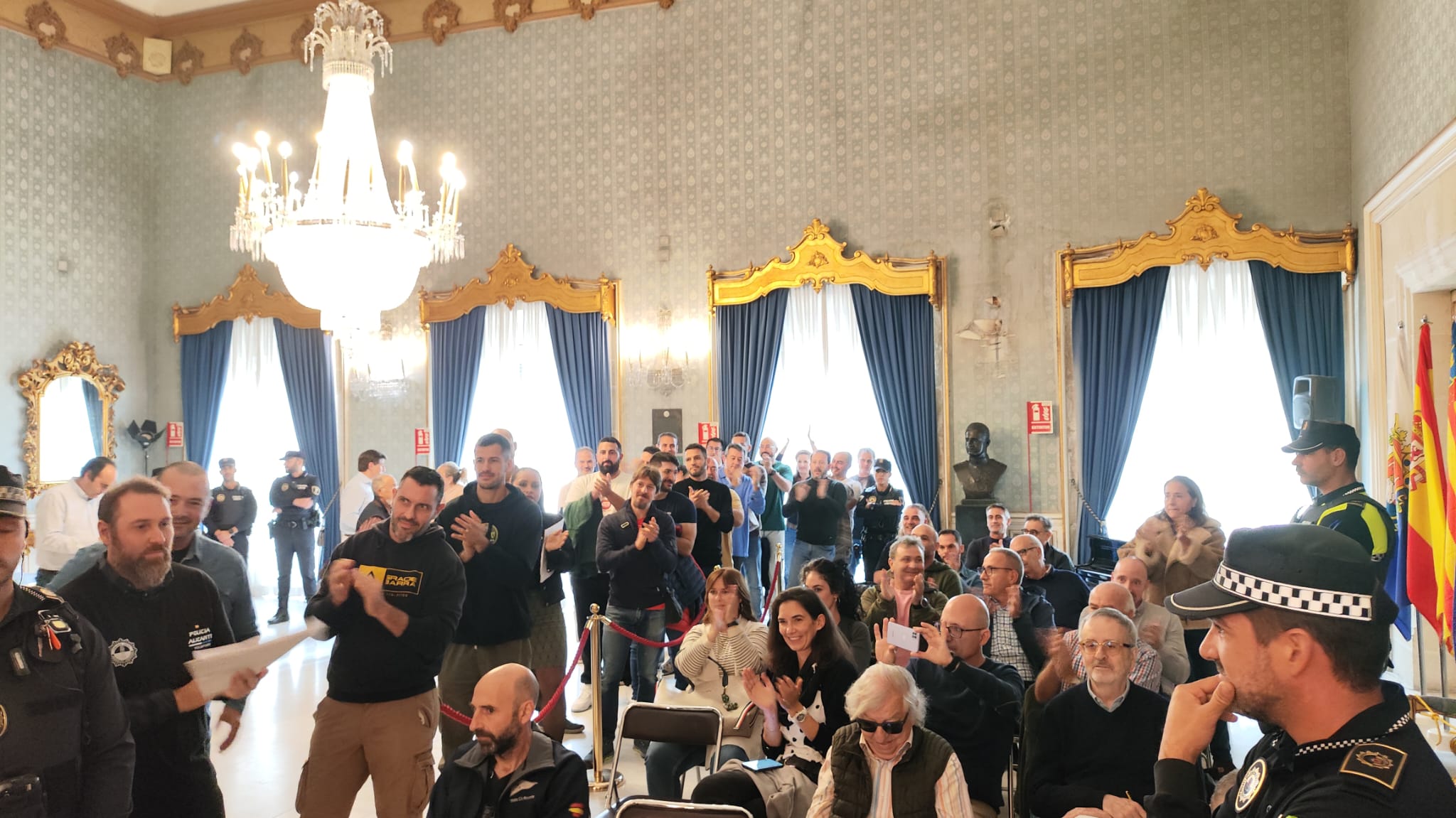 Agentes Policía Local Alicante, de paisano, aplauden tras la intervención de sus compañeros en el Pleno