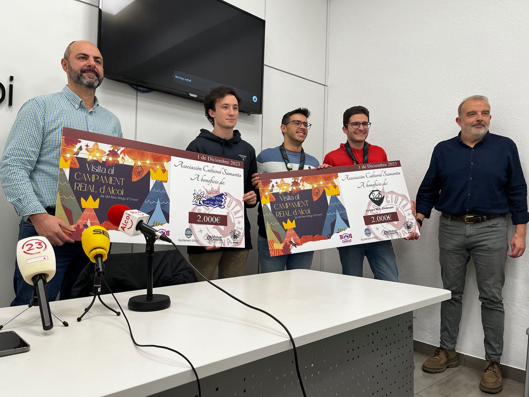 David Ponsoda y Jordi Martínez entregando los cheques a representantes de entidades juveniles por el dinero recaudado en el pasado Campamento Real