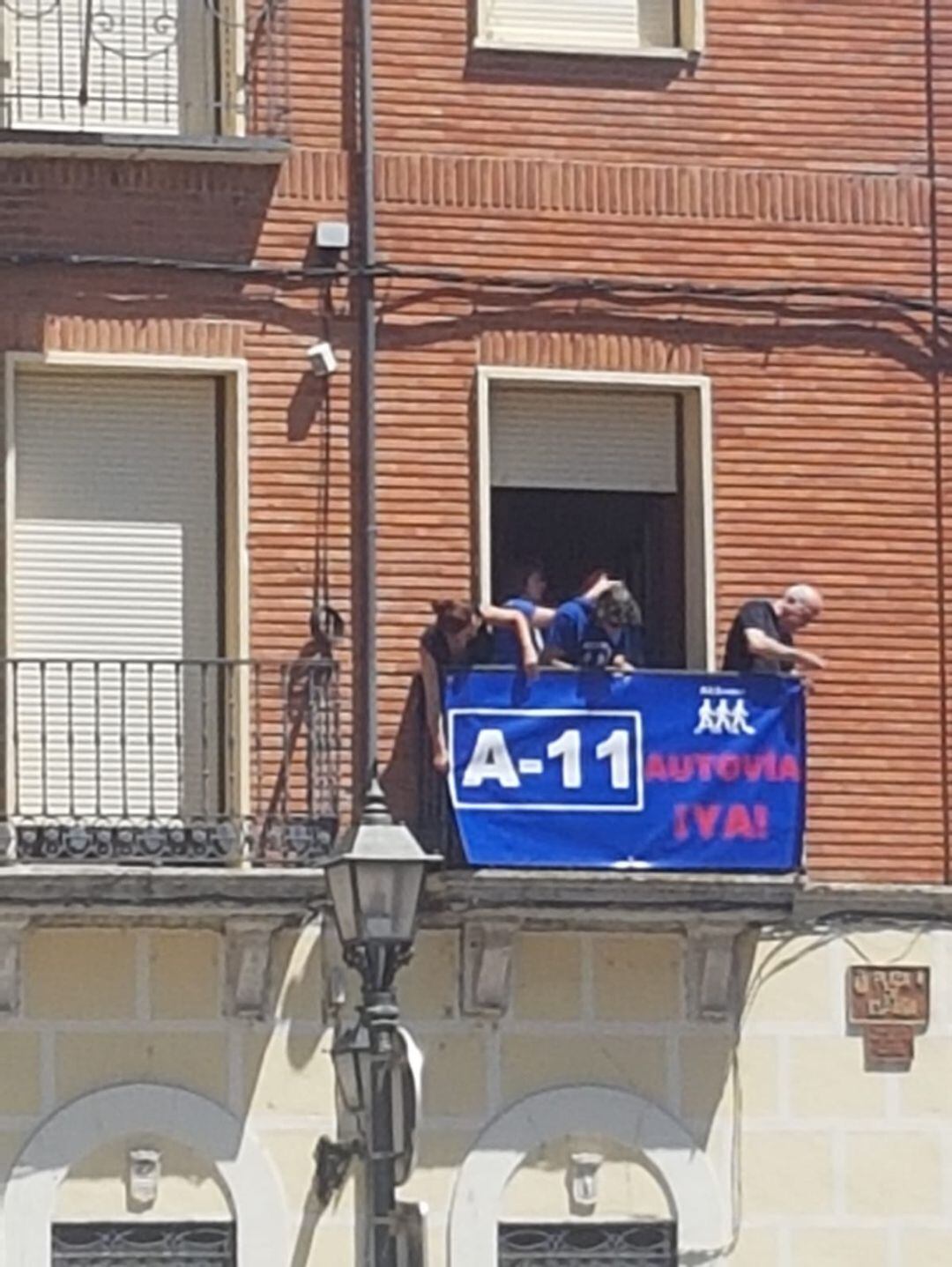 Momento de la colocación de la pancarta en uno de los balcones del Ayuntamiento