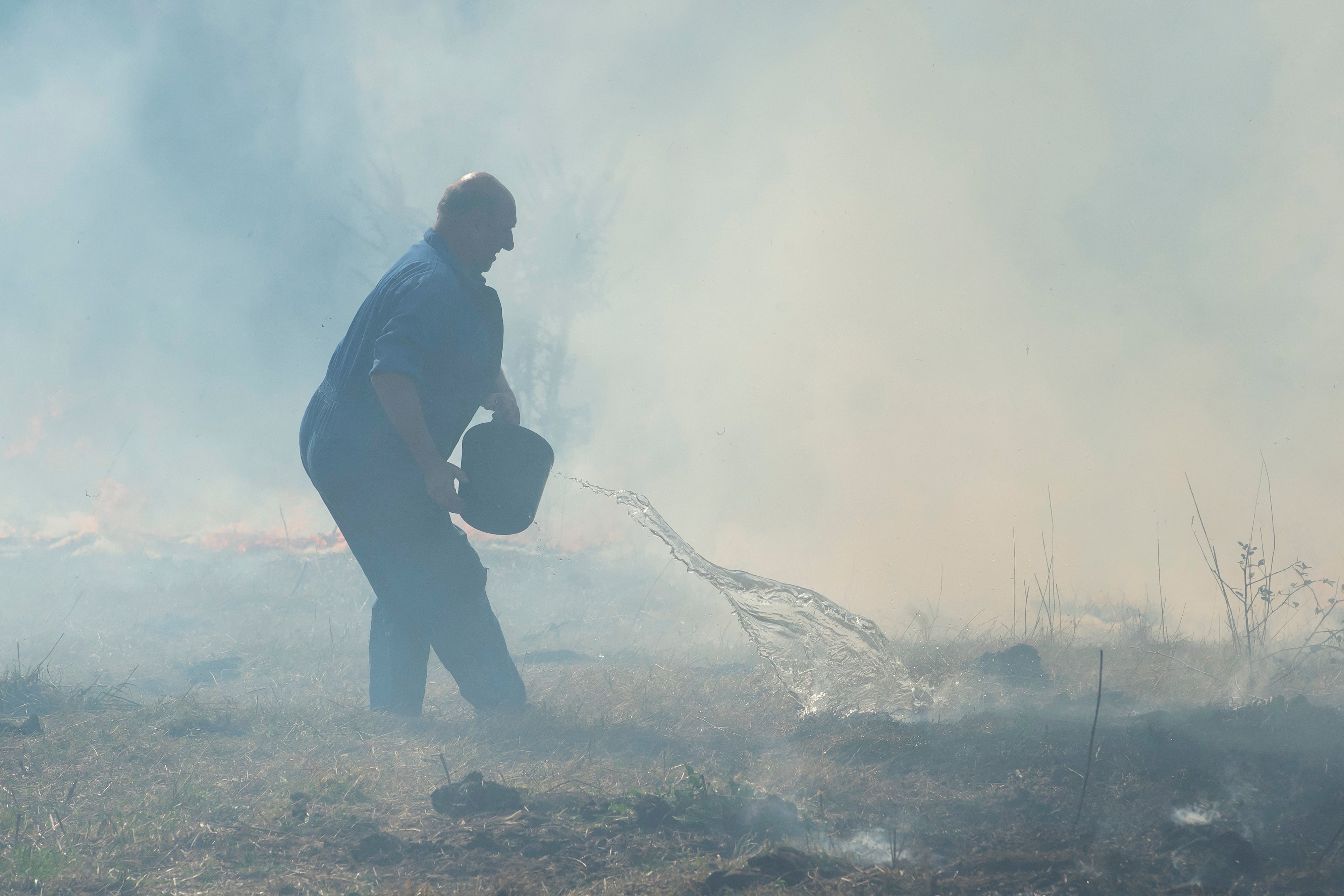 Vecinos de Bostronizo luchan contra el incendio forestal, declarado este sábado, en los montes de esta localidad Cántabra. EFE/Pedro Puente Hoyos