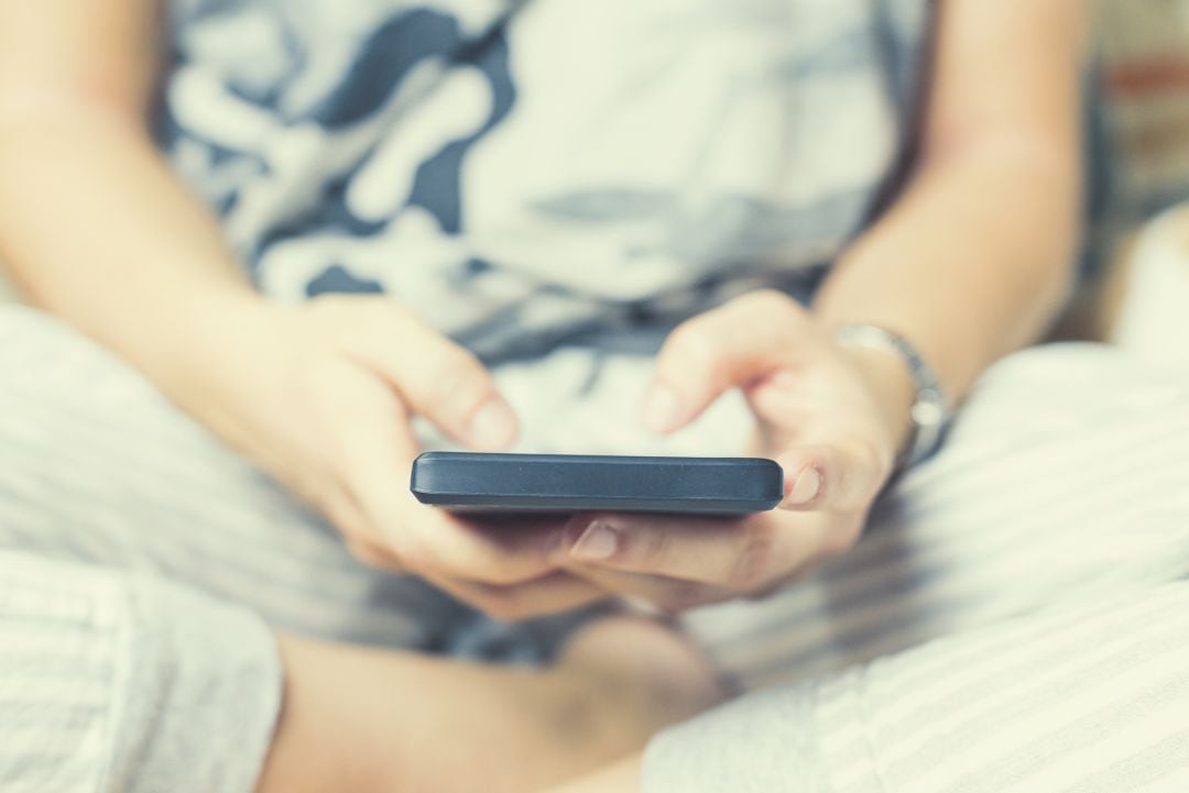 Imagen de recurso de una chica manejando su teléfono móvil.