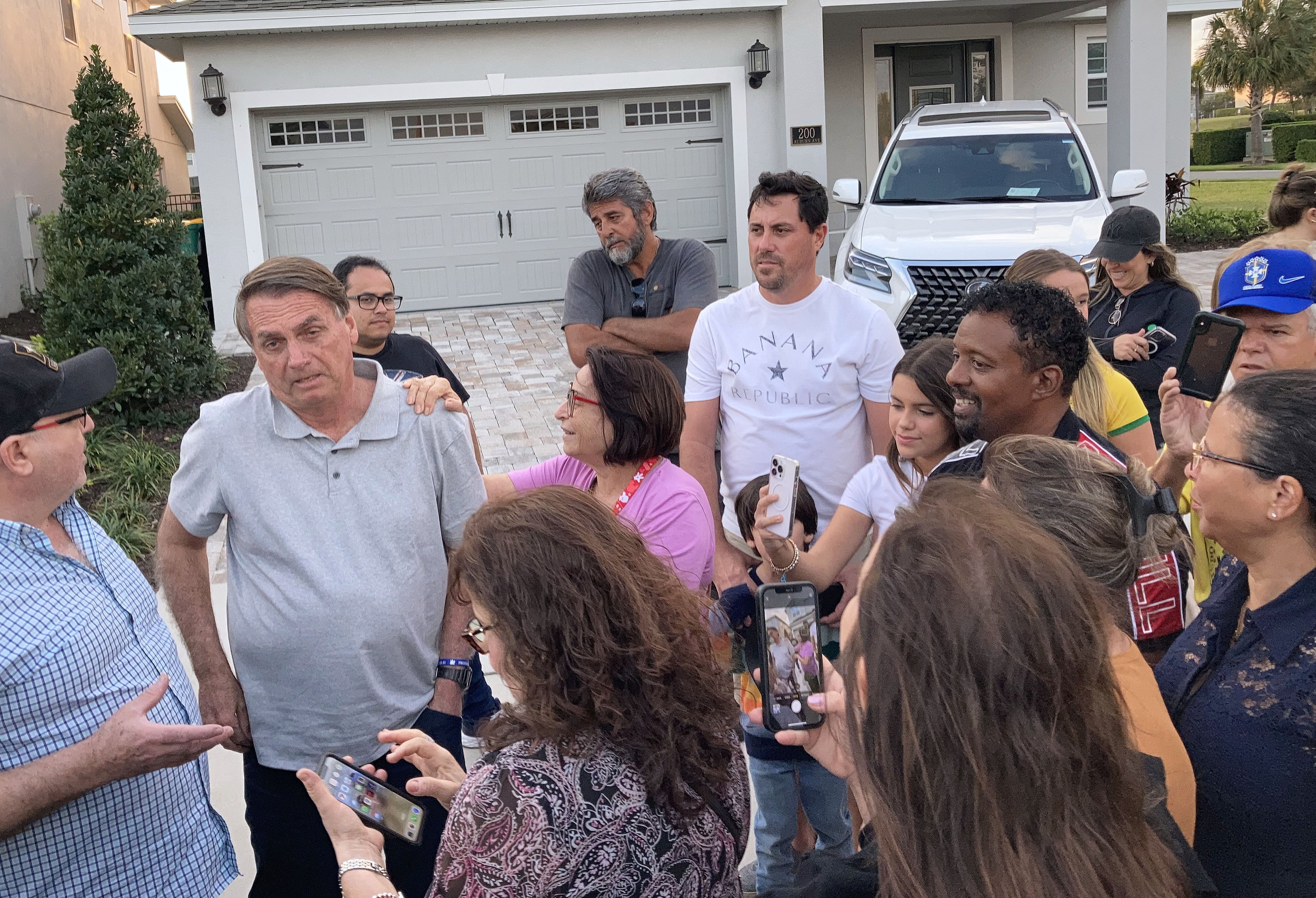 El expresidente ultraderechista de Brasil, Jair Bolsonaro, conversa y se fotografía con sus seguidores delante de la casa donde vive en Florida