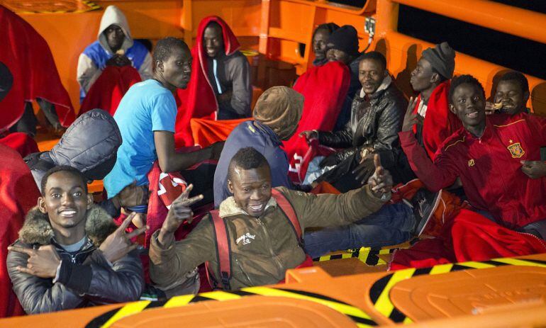 Varios de los veinticinco inmigrantes rescatados esta tarde cuando navegaban en una patera a unas 47 millas de Motril, a su llegada esta noche al puerto granadino