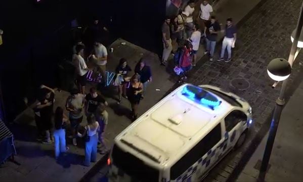 Imagen de gente, con la Policía Local, ante el bar en la calle Argensolas, tomada por las denunciantes