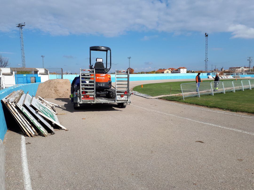 Los trabajos de retirada de vallas en el fondo del terreno de juego.