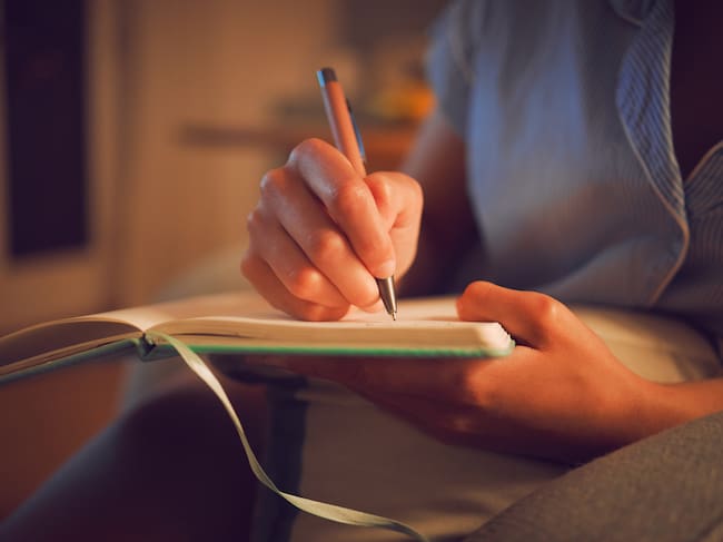Persona escribiendo en una libreta