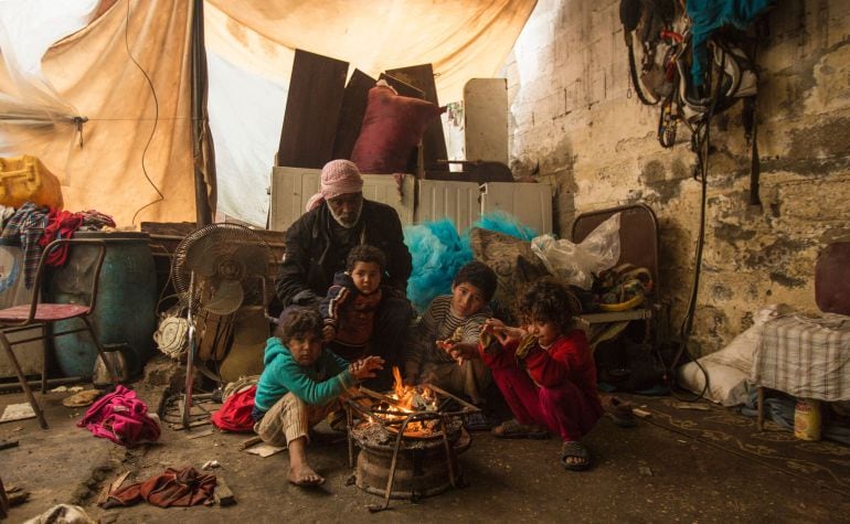 Niños alrededor del fuego en un campo de refugiados de Gaza