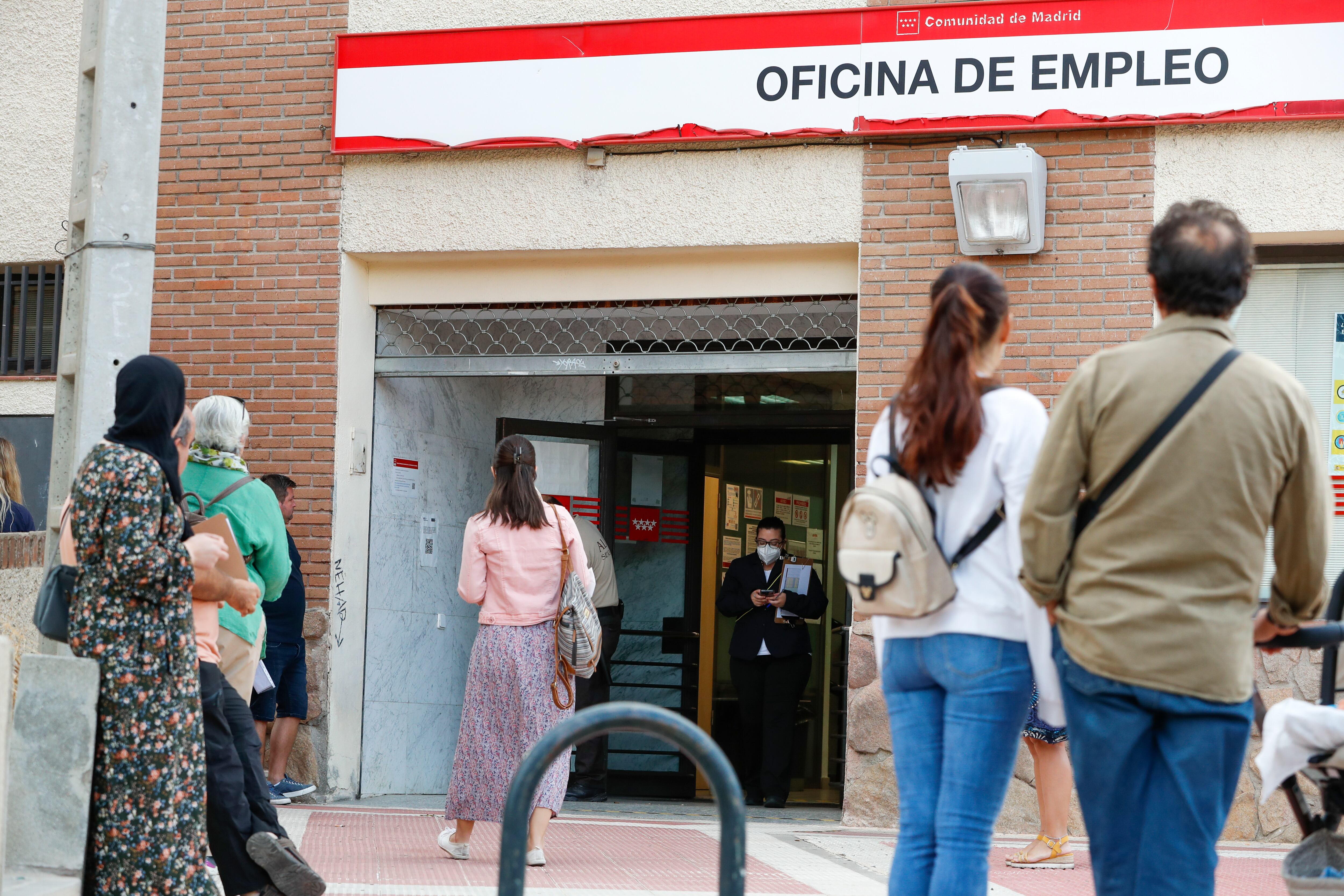 Varias personas hacen cola para acceder a una oficina de empleo en Madrid