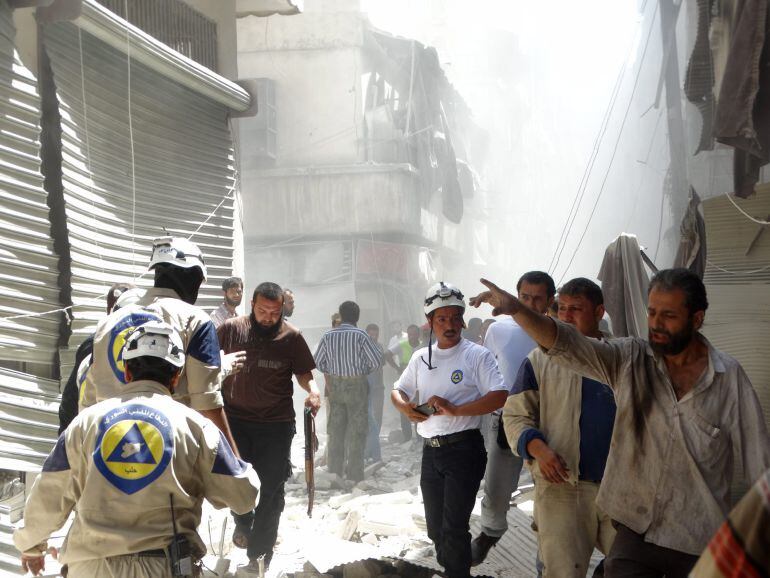 Varias personas en el lugar de ataques aéreos en Alepo (Siria).