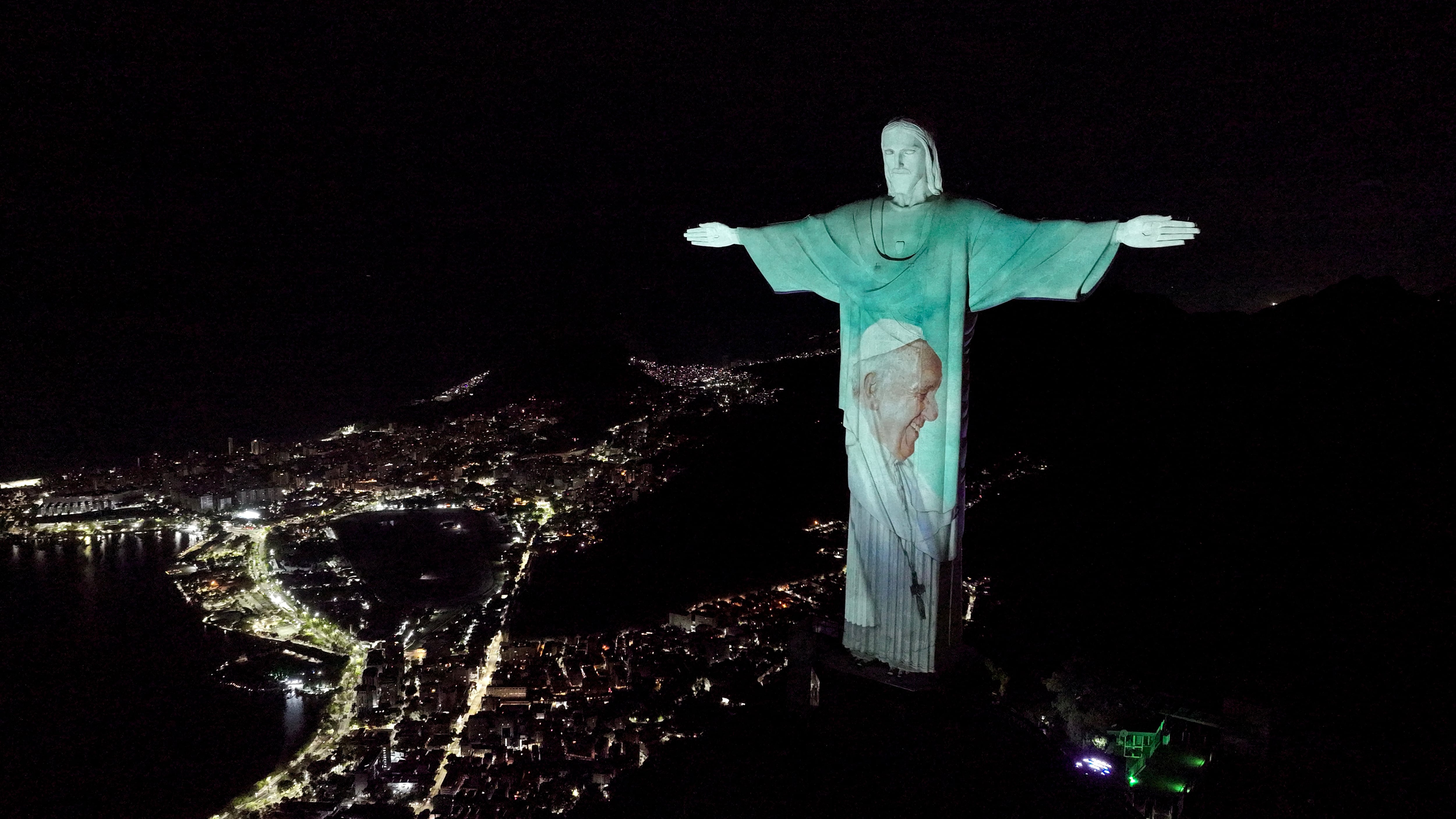 Fotografía cedida por la App Hallow del monumento del Cristo Redendor iluminado con una imagen del papa Francisco para pedir por la salud del sumo pontífice.