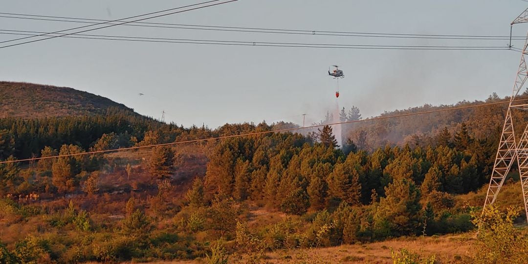 Uno de los helicópteros descargando en la zona afectada por las llamas