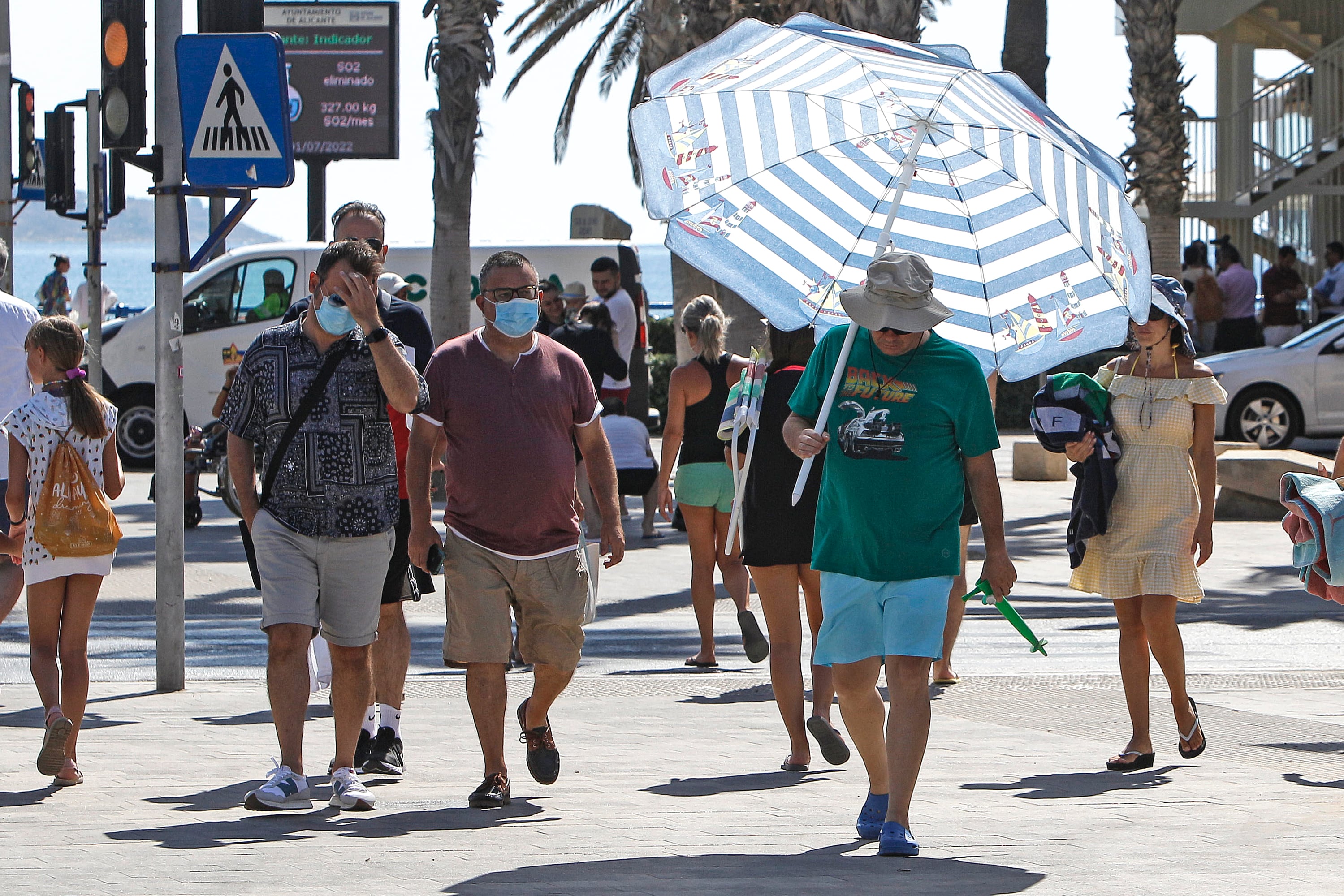 Un hombre se protege del intenso calor con una sombrilla de playa por las calles de la ciudad de Alicante. Imagen de archivo. EFE/Pep Morell