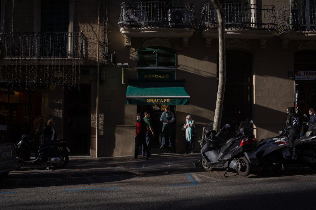 Personas en el exterior de un bar, en Barcelona, Cataluña