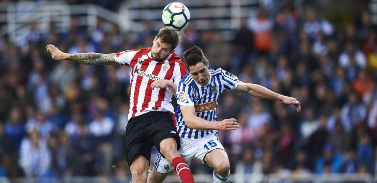 Inigo Martinez of Athletic Club (L) competes for the ball with Aritz Elustondo of Real Sociedad (R) during the La Liga match between Real Sociedad and Athletic Club at Estadio de Anoeta on April 28, 2018 in San Sebastian