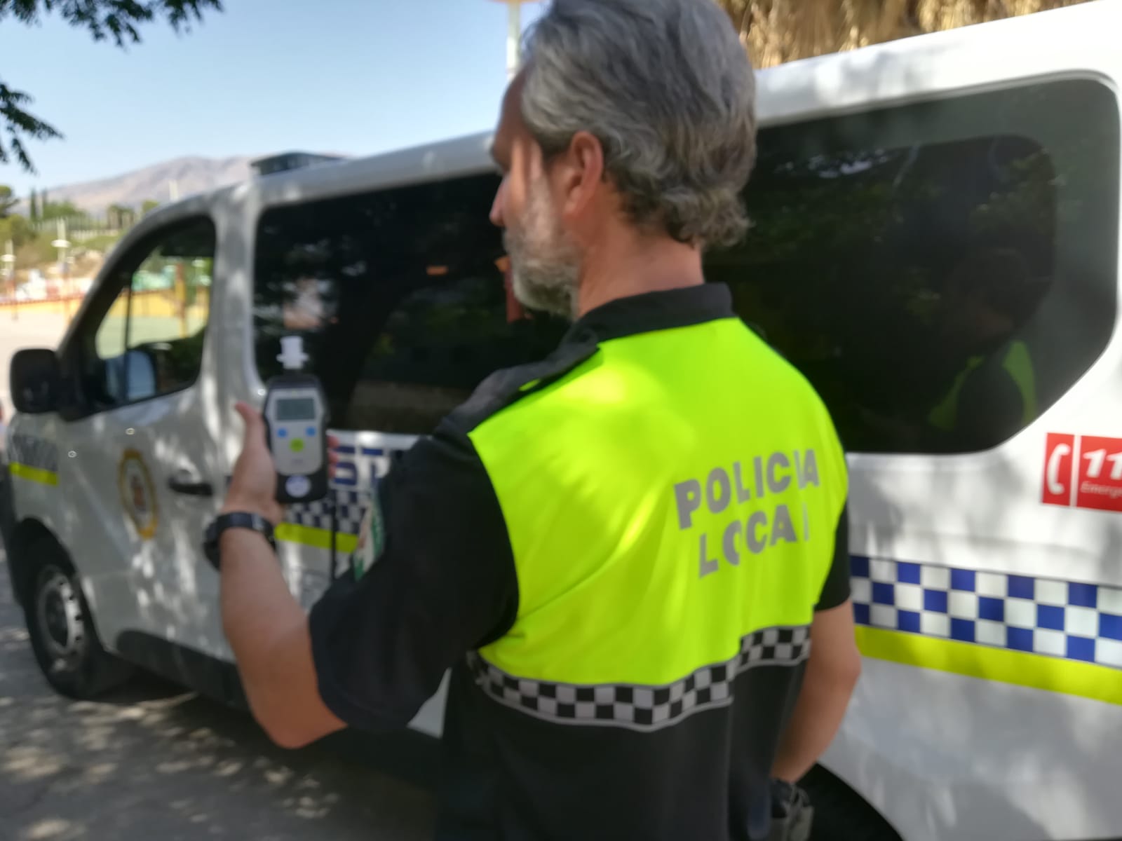 Un policía local de Jaén consulta un alcoholímetro.