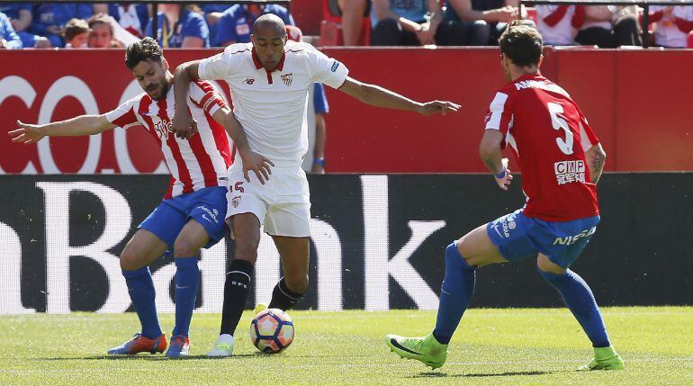 El centrocampista francés del Sevilla Steven N'Zonzi lucha un balón con los defensas del Sporting de Gijón.